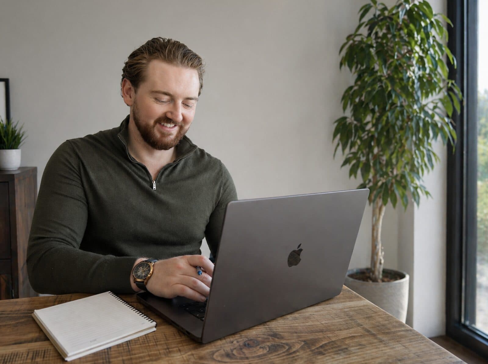 Dr Peter McCann Strain working on a laptop at a wooden table